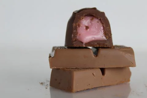 Candy and chocolate lie a stack of slides on a white background with a place Stock Photos