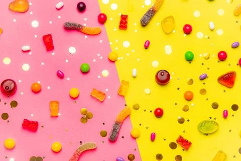 Candy assorted layout. Layout with candy on a yellow-pink background. Chewy Stock Photos