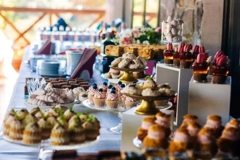 Candy bar. Table with different cakes, candies and desserts for the party Stock Photos