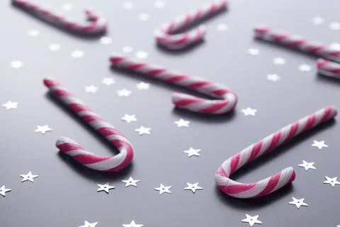Candy cane on black gradient background with stars. Stock Photos