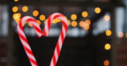 Candy cane heart frames swirling red stripes as bokeh twinkles behind, letting Stock Footage 301524850