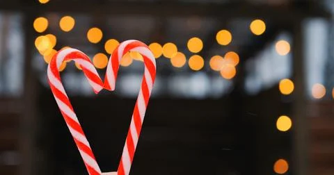 Candy cane heart frames swirling red stripes as bokeh twinkles behind, letting 스톡 사진