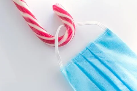 Candy cane with hookedand blue protective medical face mask for Covid-19. Chr Foto stock
