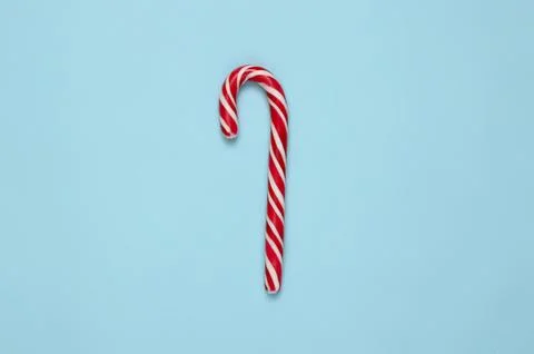 Candy cane with red and white stripes on blue background Stock Photos