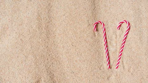 Candy cane on the sandy beach. new year and xmas vacation in hot countries at Foto stock