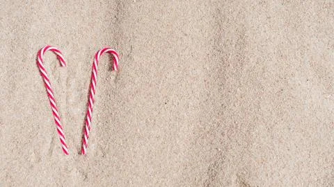Candy cane on the sandy beach. new year and xmas vacation in hot countries at Stock Photos