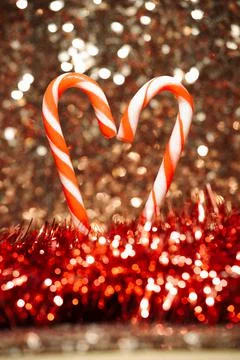 Candy cane on sequin and tinsel background Stock Photos