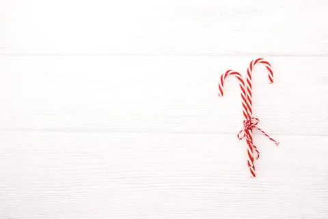 Candy canes and bow on white wooden desk Stock Photos