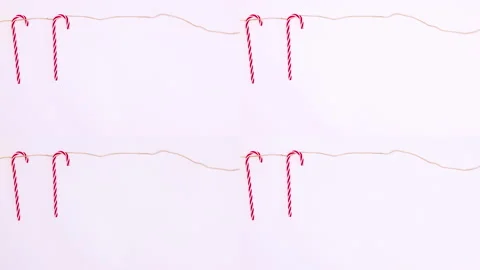 Candy canes hooking on rope on white theme. Stop motion Stock Footage 166217864