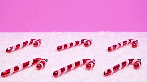 Candy Canes Materialize on Snow on a Pink Background in Stop Motion Stock-Footage 253749536