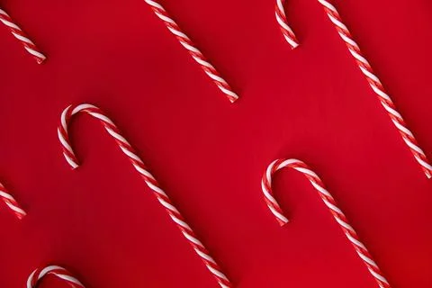 Candy canes pattern top view on bright red background Stock-Fotos