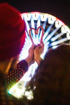 Candy canes in the shape of heart on the background of the ferris wheel Stock Photos