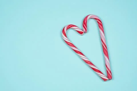Candy canes in the shape of a heart on a light blue background Stock Photos