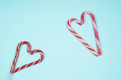 Candy canes in the shape of a heart on a light blue background Stock Photos