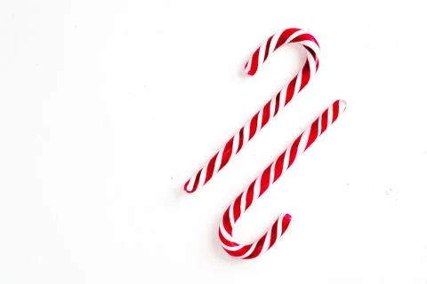 Candy canes on a white surface, top view, place for text Stock Photos