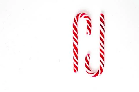 Candy canes on a white surface, top view, place for text Stock Photos