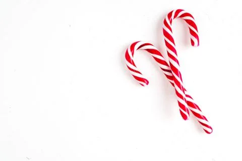 Candy canes on a white surface, top view, place for text Photos