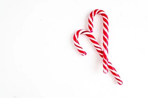 Candy canes on a white surface, top view, place for text Stock Photos
