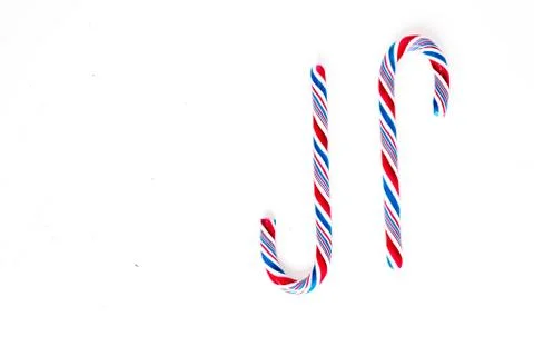 Candy canes on a white surface, top view, place for text Stock Photos