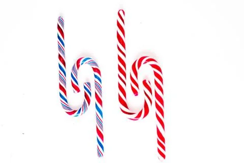 Candy canes on a white surface, top view, place for text Photos