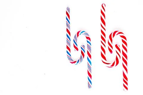 Candy canes on a white surface, top view, place for text Stock Photos