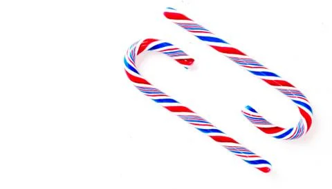 Candy canes on a white surface, top view, place for text Photos