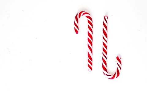 Candy canes on a white surface, top view, place for text Photos