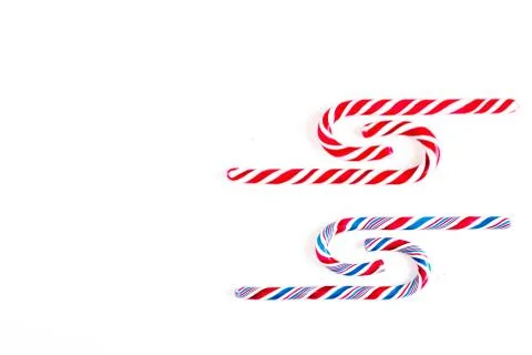 Candy canes on a white surface, top view, place for text Stock Photos