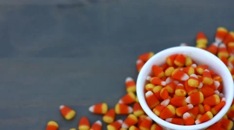 Candy corn for halloween falling into a white bowl with copy space Stock Footage 54638928