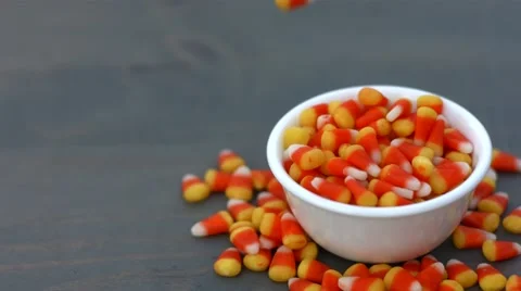Candy corn for halloween falling into a white bowl with copy space Stock Footage 54639123