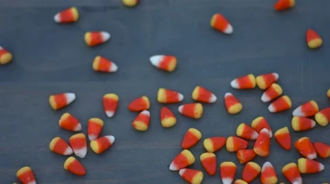 Candy corn for halloween slides across a wood background in slow motion Stock Footage 54637785