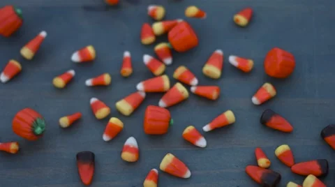Candy corn for halloween slides across a wood background in slow motion Stock Footage 54637968