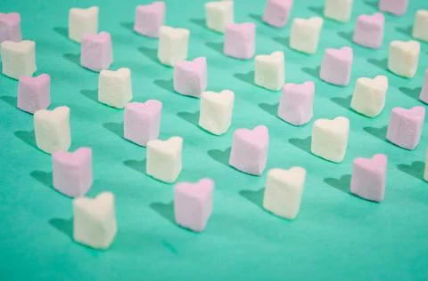 Candy of different colors on a turquoise background, a heart texture on Valen Stock Photos