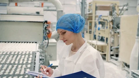 Candy factory. Controller checking conveyor with candies. Stock Footage 98019900