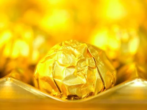 Candy in gold wrappers Stock Photos