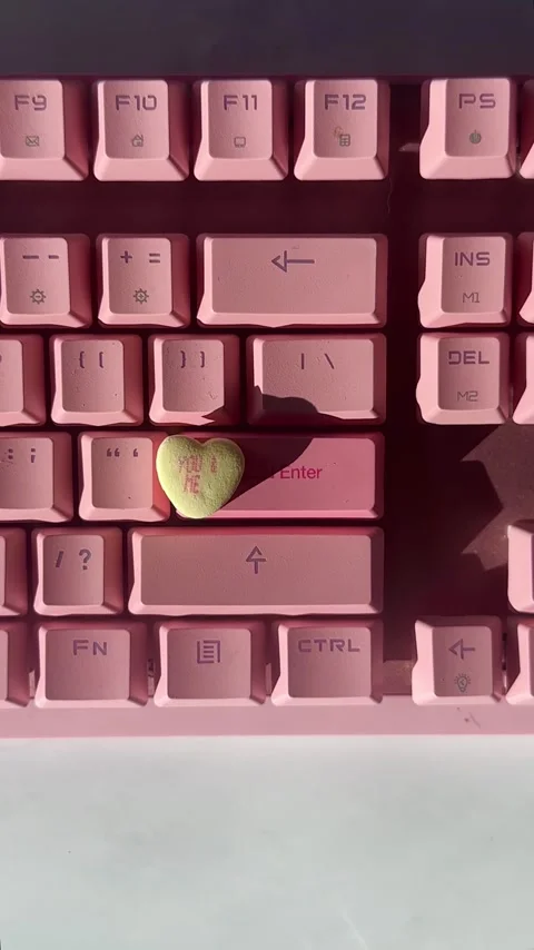 Candy heart on pink keyboard in sunlight Stock Footage 325286923