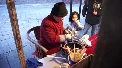 A candy maker creates a rat out of candy in Gubei Water Town's market for Stock Footage 151223758