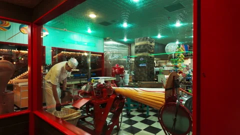 Candy Maker Preparing Sweets in Colorful Old Fashioned Shop. viewed through a Stock Footage 321042111