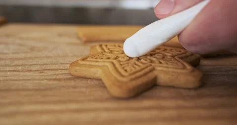 Candy maker profusely squeezes the white cream from the cooking bag onto the Stock Footage 259694835