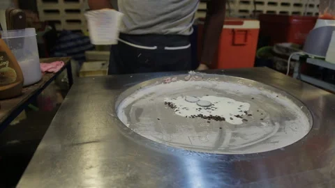 Candy panckake is being cooked in asian restaurant on a big steel round pan. Stock Footage 87307749
