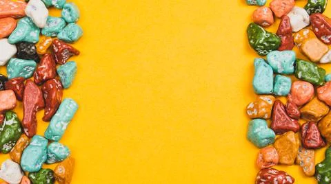Candy pebbles on a yellow background. sweets in the form of colored stones. f Stock Photos