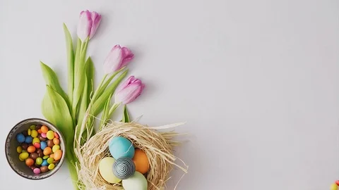 Candy rolling on table decorated with Colorful Easter eggs on bright backgrou 動画素材 124465236