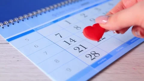 Candy in the shape of a heart falling on the calendar on February 14 Vidéo 169960813