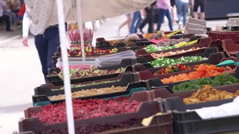 Candy stall displaying colorful gummy treats and sweets at a busy street food Stock Footage 346186560