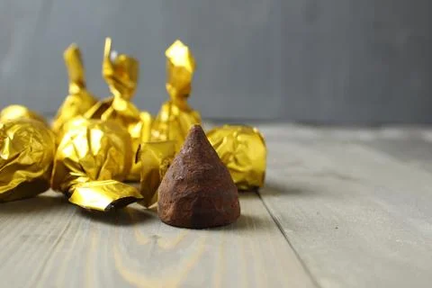 Candy truffle on a gray background. Chocolate cone shaped praline candy on a  Stock Photos