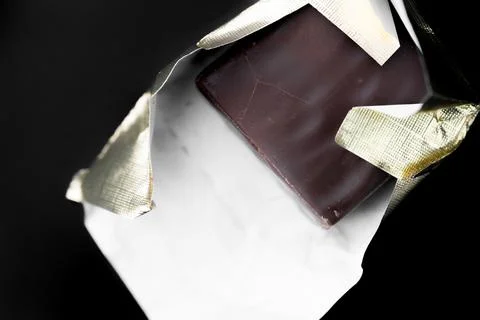 Candy in a wrapper on a black background Stock Photos