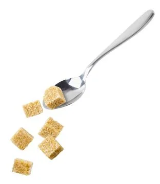 Cane sugar cubes falling from a spoon on a white background. Isolated Stock Photos