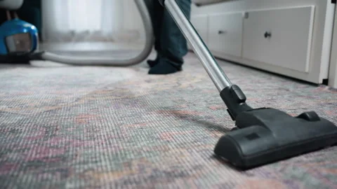 Canister vacuum cleaning patterned carpet with gentle strokes. Morning light Stock Footage 342339082