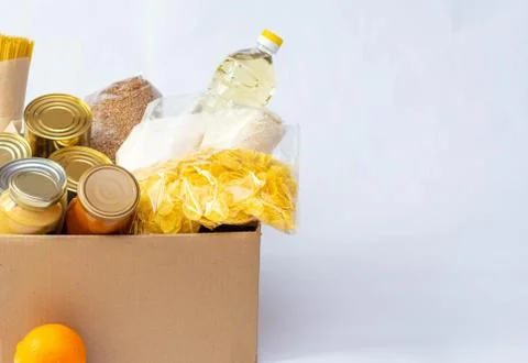 Canned food, pasta and cereals cardboard box. Food donations or food delivery Stock Photos