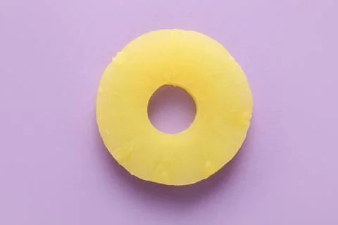 Canned pineapple ring on lilac background Stock Photos